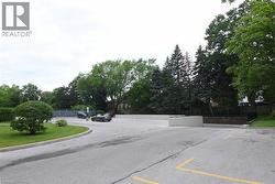 Expansive paved parking area featuring multiple marked spaces and a curbed median with mature landscaping - 