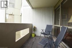 Outdoor patio with textured wall cladding, a concrete half-wall with a rectangular cutout, and dark-toned paver flooring - 