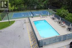 Recreational amenities featuring a fenced swimming pool with concrete surround and a fenced tennis court - 