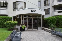 Main entrance featuring large glass doors, a stone facade, and a covered entry - 