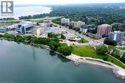 Coastal cityscape featuring expansive water frontage, established trees, and varied architectural styles - 