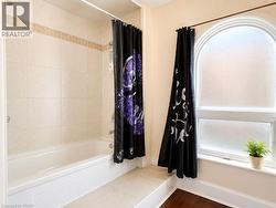 Bathtub with tiled surround featuring a decorative accent band - 