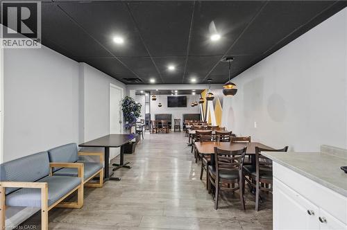 Spacious interior featuring a black drop ceiling with recessed lighting, light gray walls, and wood-finish flooring - 239 York Boulevard, Hamilton, ON 