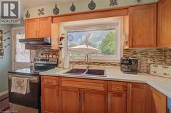 Kitchen featuring wood-finish cabinetry, light-toned countertops, and a mosaic tile backsplash - 