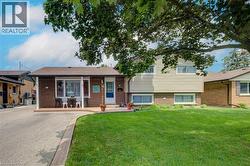 Split-level residence featuring brick and siding exterior, a front entry porch, and an attached driveway - 