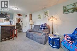 Finished basement area featuring wall-to-wall carpeting and a built-in bar with a paneled front - 