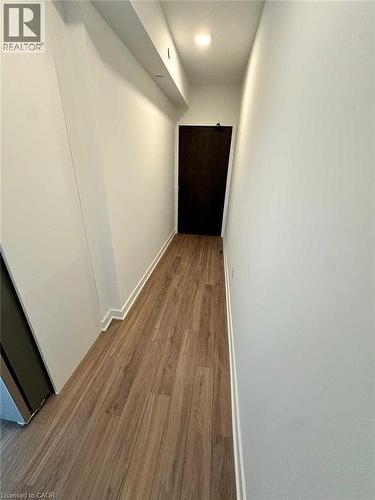 Hallway featuring wood-finish flooring, white baseboards, and a recessed ceiling light - 2782 Barton Street E, Hamilton, ON 