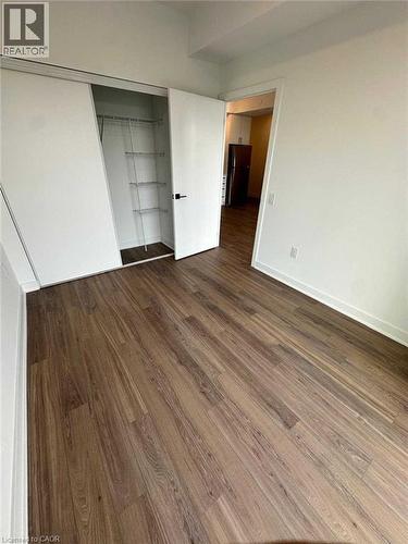 Spacious room with wood-finish flooring, white walls, and a closet with sliding doors - 2782 Barton Street E, Hamilton, ON 