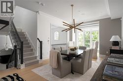 Dining area featuring a contemporary sputnik chandelier, large windows, and light wood-finish flooring - 