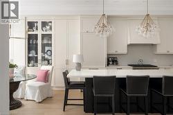 Kitchen featuring light-tone wood-finish flooring and extensive white cabinetry - 