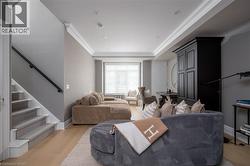Staircase featuring carpeted treads and a black handrail - 