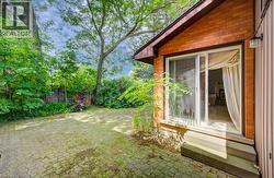 Exterior brick facade with sliding glass patio doors opening to a paver patio - 