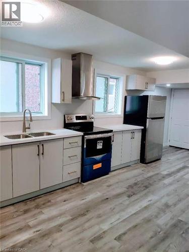 Modern kitchen featuring light gray cabinetry, white countertops, stainless steel appliances, and wood-finish flooring - 389 Tealby Crescent Unit# Lower, Waterloo, ON 