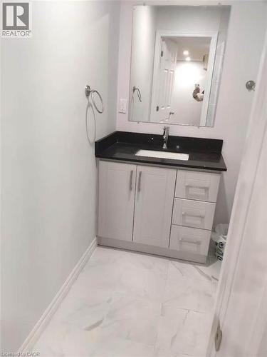 Modern vanity featuring a dark countertop with an integrated sink and chrome faucet - 389 Tealby Crescent Unit# Lower, Waterloo, ON 