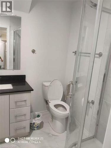Bathroom featuring a white vanity with dark countertop, undermount sink, three storage drawers, and a clear glass shower enclosure - 389 Tealby Crescent Unit# Lower, Waterloo, ON 