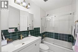 Bathroom featuring a white vanity with an integrated sink, gold-tone faucet, and paneled cabinetry - 
