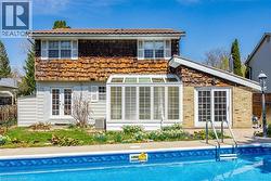 In-ground swimming pool with a patterned tile border and stainless steel entry rails - 