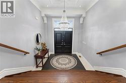 Entryway featuring a double black door with transom window, a prominent crystal chandelier, and dark tile flooring - 