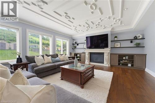 Living area featuring an ornate coffered ceiling and rich wood-finish flooring - 38 River Valley Drive, Kitchener, ON 