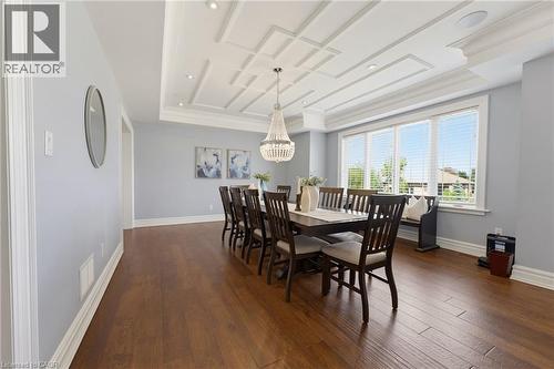 Formal dining space featuring coffered ceilings with recessed lighting, wood-finish flooring, and crown molding - 38 River Valley Drive, Kitchener, ON 