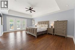 Spacious interior featuring rich wood-finish flooring and a tray ceiling with recessed lighting - 