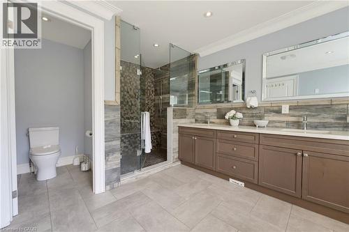 Bathroom featuring a spacious walk-in shower with glass enclosure, dual vanity with quartz countertops, and tile flooring - 38 River Valley Drive, Kitchener, ON 