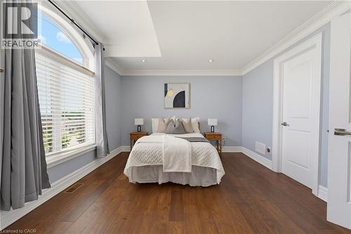 Spacious room featuring wood-finish flooring, a large arched window, recessed lighting, and crown molding - 38 River Valley Drive, Kitchener, ON 
