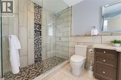 Walk-in shower featuring a glass enclosure, rain shower head, and built-in niche shelving with mosaic tile accent - 
