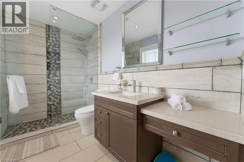 Contemporary bathroom featuring a glass-enclosed shower with custom tile work, a rain shower head, and an integrated niche - 38 River Valley Drive, Kitchener, ON 