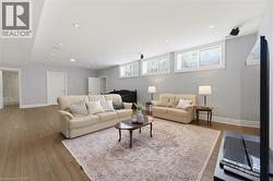 Spacious living area featuring wood-finish flooring and recessed ceiling lights - 