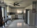 Kitchen featuring white cabinetry, light-toned countertops, a white tile backsplash, and tile flooring - 19 Glenayr Street, Hamilton, ON 