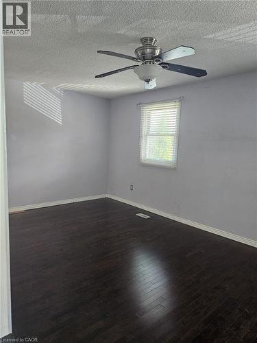 Room featuring dark wood-finish flooring and light purple walls - 19 Glenayr Street, Hamilton, ON 