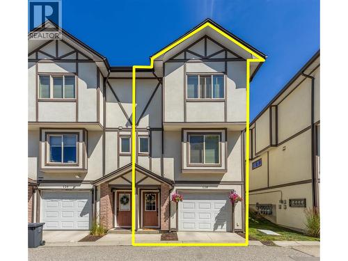 Tandem garage and entry door. Dining room window on main floor and primary suite window on upper floor. - 128-1651 Lynrick Road, Kelowna, BC 