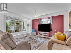 Nice, bright living room with the window looking out onto the front deck. - 