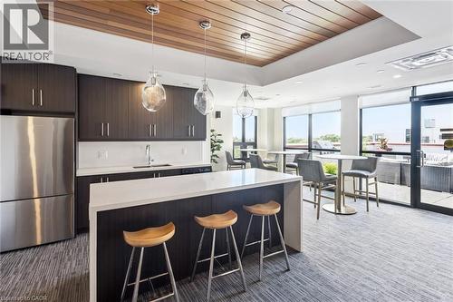 Kitchen area featuring dark wood-finish cabinetry and a white countertop island - 340 Plains Road E Unit# 507, Burlington, ON - Indoor Photo Showing Kitchen With Stainless Steel Kitchen With Upgraded Kitchen