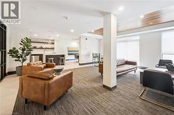 Open concept common area featuring a built-in wet bar with a white countertop and integrated sink, recessed lighting, and a wood-slat ceiling accent - 