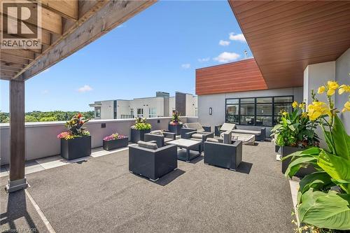Expansive rooftop terrace featuring a textured flooring surface and contemporary planters - 340 Plains Road E Unit# 507, Burlington, ON - Outdoor With Deck Patio Veranda With Exterior