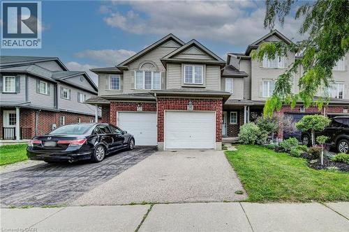 Brick and siding exterior featuring an attached single-car garage, a paved driveway, and a covered front entry - 208 Featherstone Crescent, Kitchener, ON - Outdoor With Facade
