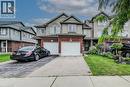 Brick and siding exterior featuring an attached single-car garage, a paved driveway, and a covered front entry - 208 Featherstone Crescent, Kitchener, ON  - Outdoor With Facade 