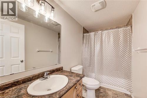 Bathroom featuring a vanity with a laminate countertop, an undermount sink, and a chrome faucet - 208 Featherstone Crescent, Kitchener, ON - Indoor Photo Showing Bathroom