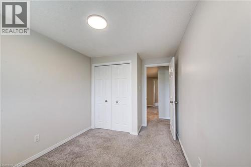 Carpeted room with neutral wall tones and a white bi-fold closet - 208 Featherstone Crescent, Kitchener, ON - Indoor Photo Showing Other Room