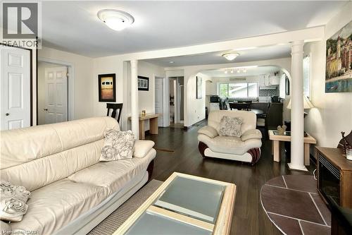 Open-concept living area featuring dark wood-finish flooring, white trim, recessed ceiling lights, and architectural columns - 42 5Th Lane, Wasaga Beach, ON - Indoor Photo Showing Living Room