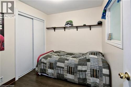 Compact room featuring wood-finish flooring, a white window frame, and a built-in wall shelf - 42 5Th Lane, Wasaga Beach, ON - Indoor Photo Showing Bedroom
