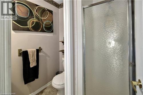 Enclosed shower with frosted glass door, adjacent to a toilet and wall-mounted towel bar - 42 5Th Lane, Wasaga Beach, ON - Indoor Photo Showing Bathroom
