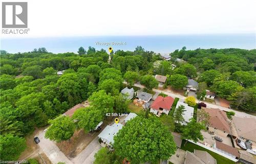 Aerial perspective showcasing the property at 42 5th Lane, nestled within a verdant treed setting - 42 5Th Lane, Wasaga Beach, ON - Outdoor With View