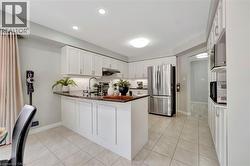 Bright kitchen featuring an island with a dark countertop and white cabinetry - 