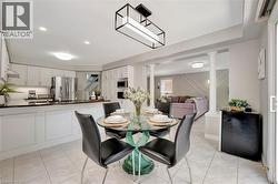 Open-concept kitchen and dining area with white cabinetry, stainless steel appliances, and dark countertops - 