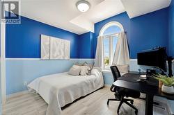 Bedroom featuring a vaulted ceiling, arched window, and light wood-finish flooring - 