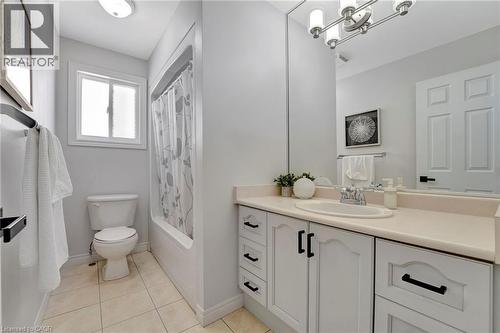 Bathroom featuring a white vanity with cream countertop, integrated sink, and brushed nickel faucet - 35 Dubrick Crescent, Kitchener, ON 