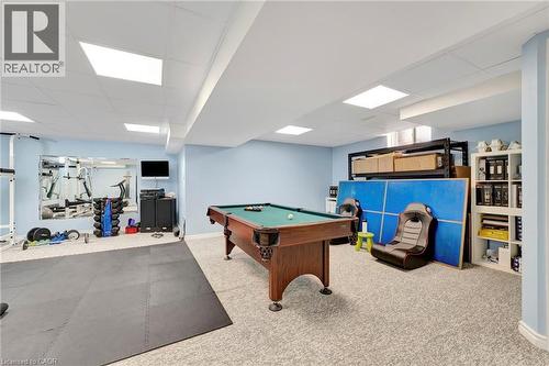 Recreational room featuring a billiard table, drop ceiling with recessed lighting, and built-in storage shelving - 35 Dubrick Crescent, Kitchener, ON 